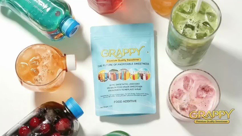 Grappy Premium Quality Sweetener pouch surrounded by bottled soft drinks and iced juices